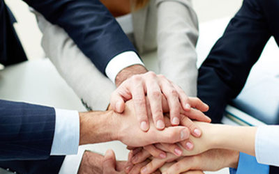Close-up of business partners making pile of hands at meeting